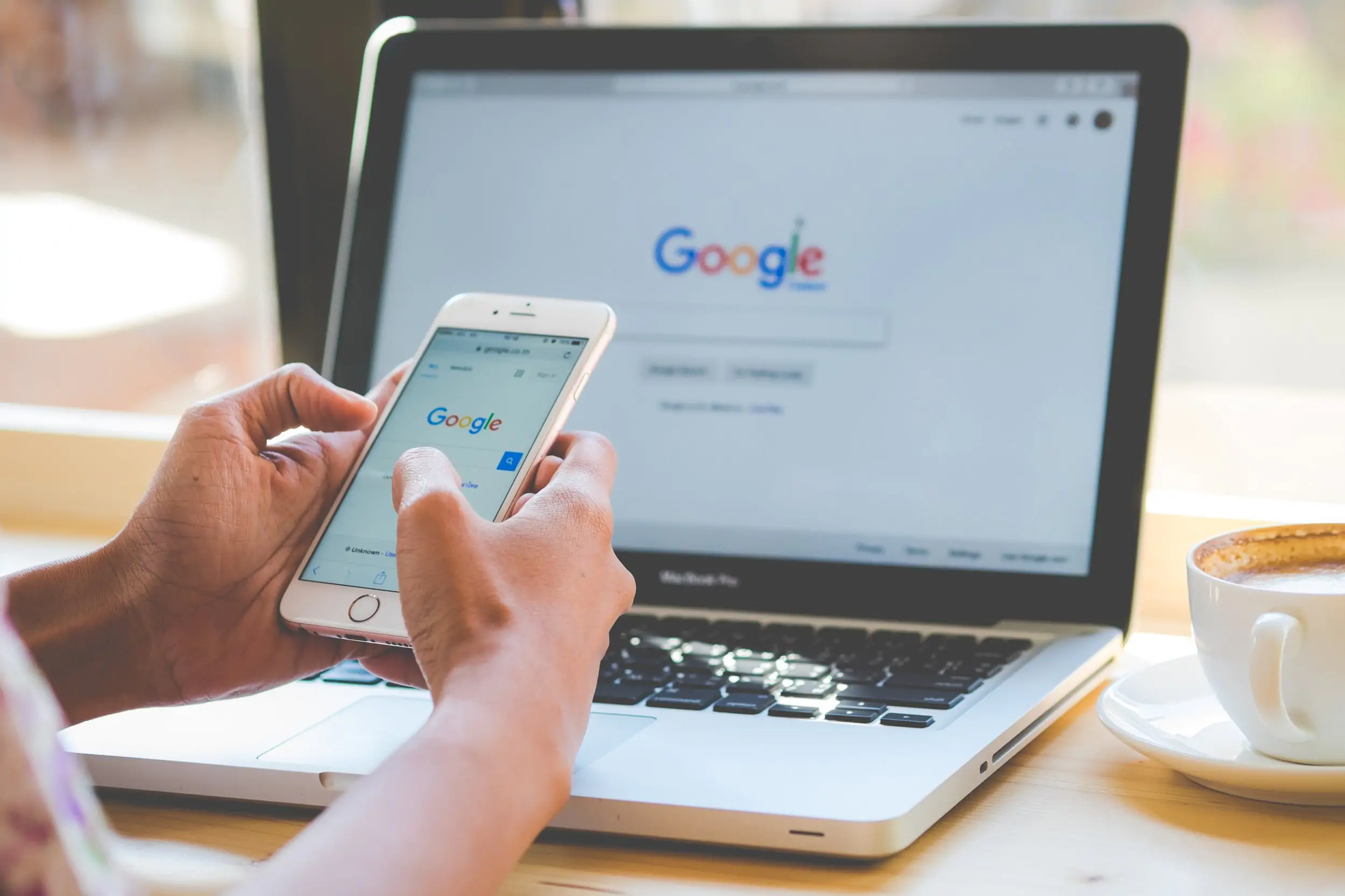 pessoa utilizando o google no computador e celular para representar um tema sobre october 2023 spam update